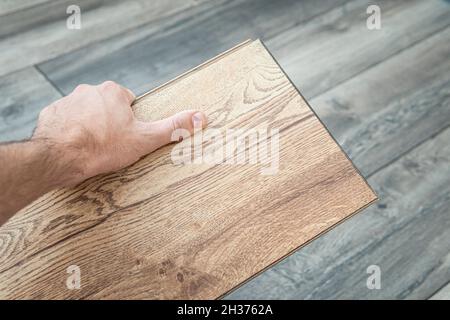 Pavimento in parquet laminato in legno, scelta di colori con vista dall'alto. Parquet in mano al maestro. Foto Stock