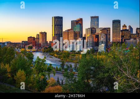 Tramonto sopra lo skyline della città di Calgary con il fiume Bow, Canada Foto Stock