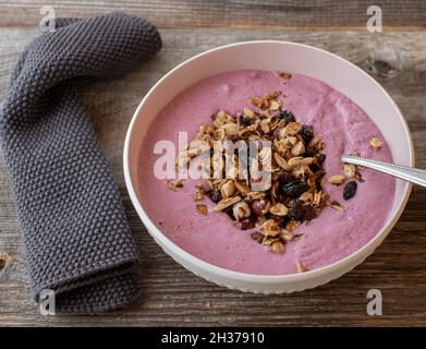 Ciotola con yogurt ai mirtilli fatti in casa con granola appena tostata Foto Stock