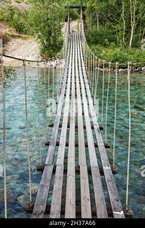 Corda di rickety ponte sul fiume che scorre veloce Foto Stock