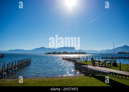 Vista di Fraueninsel sul lago di Chiemsee in una mattinata d'autunno limpida con le alpi sullo sfondo e contraglie Foto Stock