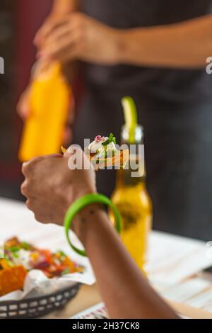 Ristorante i visitatori mangiano spuntini messicani nachos con guacamole e salsa Pico de gallo Foto Stock