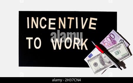 INCENTIVE TO WORK text è scritto su uno sfondo a specchio nero in lettere di legno. Foto Stock