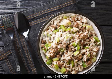 Cajun riso sporco con fegato di pollo, carne tritata, sedano e pepe e primo piano in una ciotola sul tavolo. Vista dall'alto orizzontale dall'alto Foto Stock