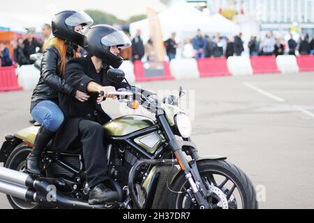 Settembre 24, 2016. Minsk, festival dei motociclisti. Ragazza in un casco e un ragazzo biker su un motociclo.Hipster amanti. Stile rock. Vintage Foto Stock