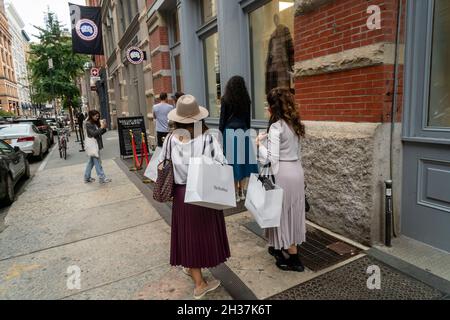 I clienti con le loro borse di lusso RealReal di spedizione aspettano in fila per entrare in un altro negozio di abbigliamento di lusso di seconda mano, che cosa va intorno viene intorno, nel quartiere Soho di New York il sabato 9 ottobre 2021. La stima per il mercato totale di rivendita di lusso negli Stati Uniti è di 6 miliardi di dollari. (© Richard B. Levine) Foto Stock