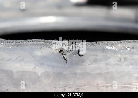 Incrinatura su un vecchio pneumatico in gomma usato per auto. Messa a fuoco selettiva. Primo piano Foto Stock