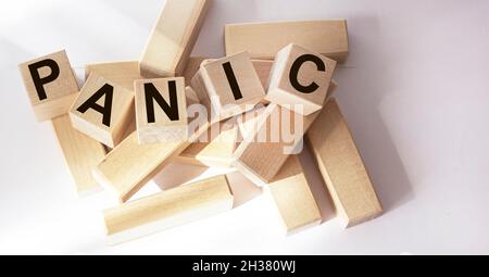 Parola di panico scritta su un blocco di legno su uno sfondo bianco. Foto Stock