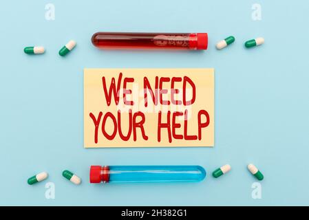 Scrittura a mano segno abbiamo bisogno del vostro aiuto. Concetto che significa chiedere a qualcuno di stare con voi contro difficoltà prescritto Medicina vitaminine e minerali Foto Stock