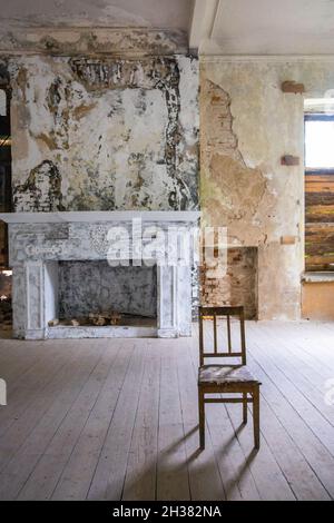 Sedia nella camera in stile loft, camino sullo sfondo, pareti shabby. Foto di alta qualità Foto Stock