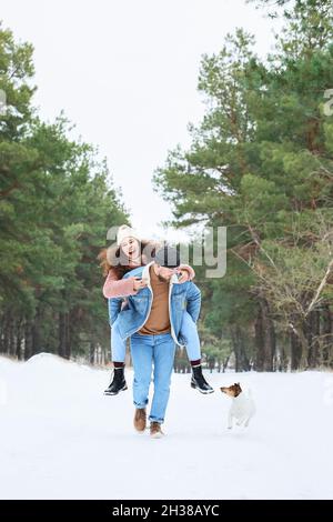 Felice giovane coppia divertirsi nella foresta il giorno d'inverno Foto Stock