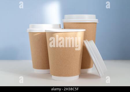 gruppo di tazze di carta su sfondo blu, concetto di greenwashing Foto Stock