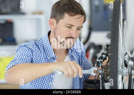 lavoratori che riparano biciclette in officina Foto Stock