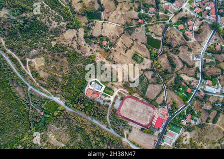 Vista aerea del drone sullo stadio di campagna nel villaggio di Velventos vicino al lago artificiale Polyfytos. Larissa, Grecia. Foto Stock