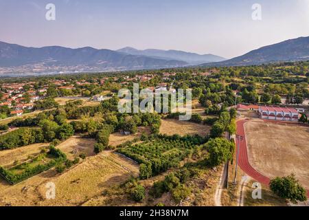 Vista aerea del drone sullo stadio di campagna nel villaggio di Velventos vicino al lago artificiale Polyfytos. Larissa, Grecia. Foto Stock