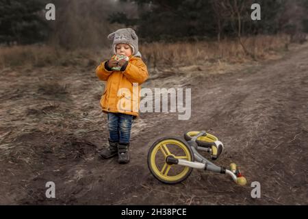 Bambino piccolo che indossa giacca gialla d'inverno per pranzo fuori Foto Stock