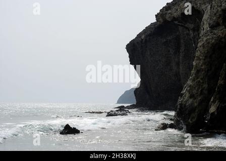 Mare con rocce vulcaniche a Cala de la Media Luna accanto alla spiaggia di Monsul a Cabo il Parco Naturale Gata nella regione di Almeria, Andalusia, Spagna. Foto Stock