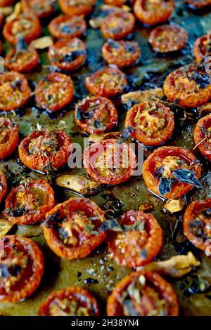 Pomodori ciliegini arrostiti in padella piatta. Cosparsa di olio d'oliva e timo, con sale marino e pepe Foto Stock