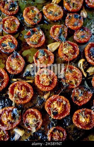 Pomodori ciliegini arrostiti in padella piatta. Cosparsa di olio d'oliva e timo, con sale marino e pepe Foto Stock