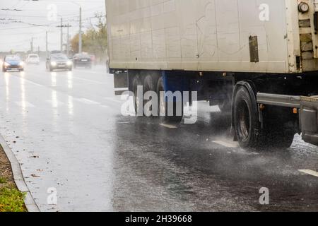 rimorchio per furgoni a secco in movimento su strada bagnata con spruzzi durante il giorno Foto Stock