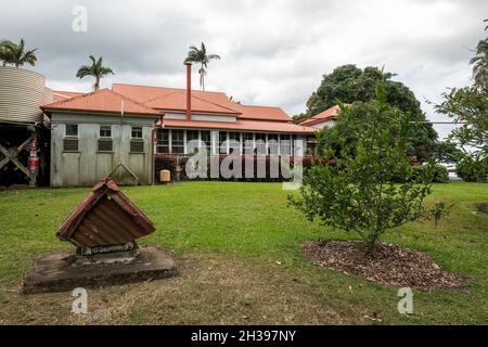 Indietro di un patrimonio storico classificato casa con un piccolo vecchio cane casa nel giardino sotto un cielo nuvoloso, Greenmount Homestead Mackay Queensland Au Foto Stock