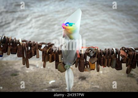 Un tributo floreale e lucchetti su una catena al Waterfront, Liverpool Foto Stock