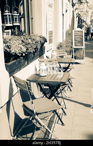 POZNAN, POLONIA - 12 luglio 2016: Un'immagine verticale di un bar all'aperto con sedie e tavoli in scala di grigi a Poznan, Polonia Foto Stock