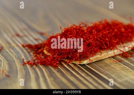 Spezia secca allo zafferano naturale su cucchiaio di legno. Foto Stock