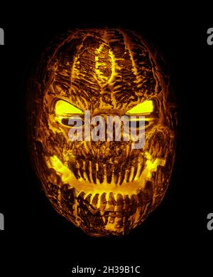 Maschera di punteggio Pumpkin illuminata isolata contro sfondo nero Foto Stock