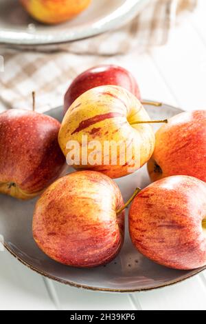 Mele autunnali fresche su piatto su tavola bianca. Foto Stock