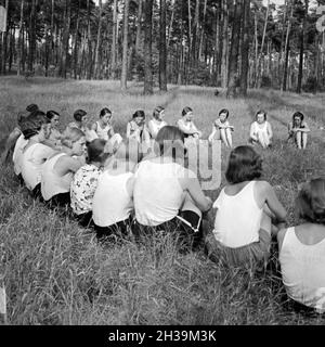 Mädchen sitzen im Wald im Freizeitlager Kreisim der Deutschen Arbeitsfront in Altenhof am Werbellinsee nel Brandeburgo, 1930er Jahre. Le ragazze sono seduti in cerchio nella foresta a Altenhof, Brandeburgo, 1930s. Foto Stock