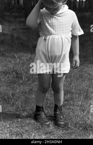 Kleiner Junge beobachtet einen Maikäfer, Deutschland 1930er Jahre. Little Boy guardando un maggio maggiolino, Germania 1930s. Foto Stock