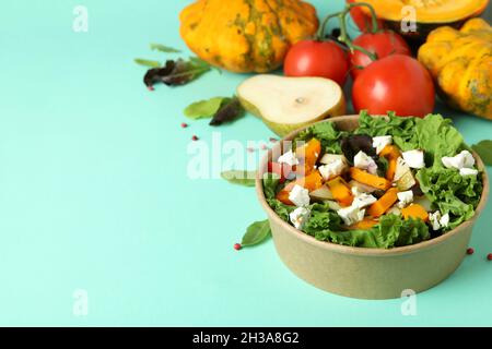 Concetto di cibo sano con insalata di zucca su sfondo menta Foto Stock