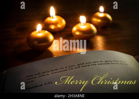 versetto della bibbia di natale con candele sullo sfondo Foto Stock