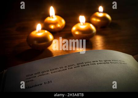 versetto della bibbia di natale con candele sullo sfondo Foto Stock