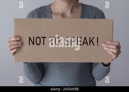 Una donna ha una bandiera con l'iscrizione DI NON PARLARE davanti a lei. Foto Stock