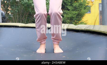 la giovane donna salta su una bambina, un primo piano. Le gambe galleggiano in aria dopo aver saltato su un trampolino. Divertimento per tutta la famiglia, intrattenimento e sport, selettivo Foto Stock