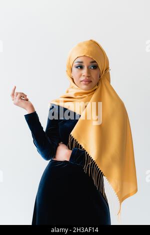 donna musulmana in hijab e abito blu velluto isolato su bianco Foto Stock