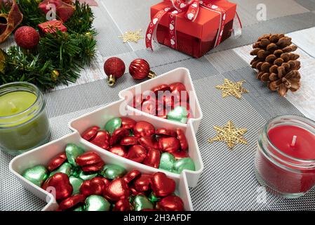 Decorazioni da tavolo per la cena di Natale con un piatto di caramelle colorate chocolate. Foto Stock