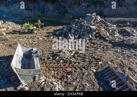 Disastro alluvionale nel 2021 nella valle dell'Ahr, Mayschoß, Germania. Tra i detriti sulla riva, una croce commemora un criminale annegato Foto Stock