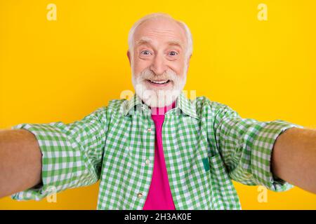 Autoritratto di attraente allegro felice uomo grigio-capelli buon umore isolato su sfondo giallo brillante Foto Stock