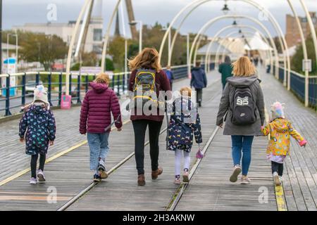 Ottobre escursione in famiglia a Southport, Merseyside. Meteo Regno Unito. 27 Ott 2021. Giornata bagnata e ventosa nella località balneare nord-occidentale. Nuvoloso e ventoso con la fascia di pioggia che si inonda dal nord-ovest. Alcune delle piogge si aspettavano a volte essere pesanti e persistenti. Credit: MediaWorldImages/AlamyLiveNews Foto Stock