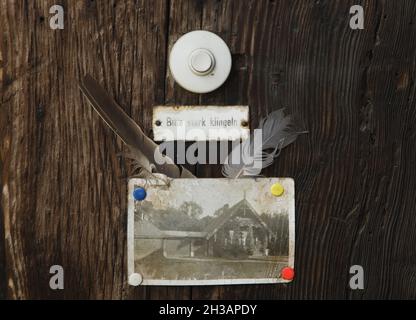 Bell Button su una delle tradizionali case di legno russe nella Colonia russa Alexandrowka (Russische Kolonie Alexandrowka) a Potsdam, Germania. La foto d'epoca della casa è fissata sotto il pulsante del campanello. L'iscrizione sotto il pulsante in tedesco significa: Si prega di suonare il campanello ad alta voce. Foto Stock