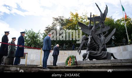 Dublino, Irlanda. 27 ottobre 2021. Il presidente federale Frank-Walter Steinmeier (r) depone una corona al Memoriale irlandese delle forze armate alla presenza di Simon Coveney (2° da destra), ministro degli Esteri irlandese. Il Presidente Steinmeier e sua moglie sono in visita di Stato di tre giorni in Irlanda. Credit: Bernd von Jutrczenka/dpa/Alamy Live News Foto Stock