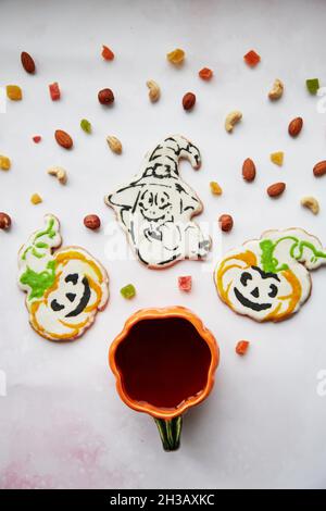 Concetto creativo di Halloween: Tazza di zucca e biscotti fatti in casa a forma di zucche carine e ghost closeup. Estetica autunno umore o trick o concetto di trattamento. Autunno accogliente concetto di casa Foto Stock