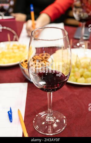 degustazione di vini rossi - vino con porzione di vino testato su tavola Foto Stock