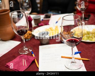 degustazione di vini rossi - vino con vino testato su note a tavola Foto Stock