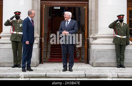 Dublino, Irlanda. 27 ottobre 2021. Il presidente federale Frank-Walter Steinmeier (centro, destra) è accolto da Micheal Martin, Taoiseach d'Irlanda, nella residenza ufficiale del primo ministro. Il Presidente Steinmeier e sua moglie sono in visita di Stato di tre giorni in Irlanda. Credit: Bernd von Jutrczenka/dpa/Alamy Live News Foto Stock