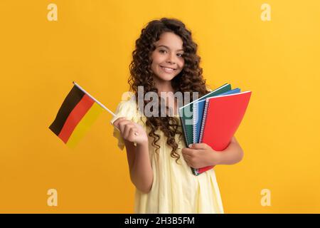 lingua tedesca. bandiera di tenuta del bambino. torna a scuola. studia teen girl in germania. infanzia felice. Foto Stock