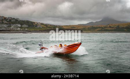 RNLI Criccieth Lifeboat Station's Atlantic 85 class scialuppa di salvataggio che alimenta attraverso le onde. Foto Stock